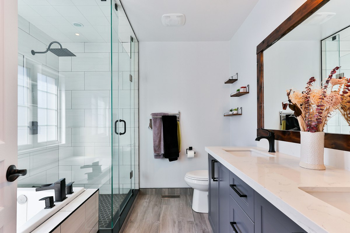 Recently finished bathroom with dual vanity and glass shower — example of fixture work